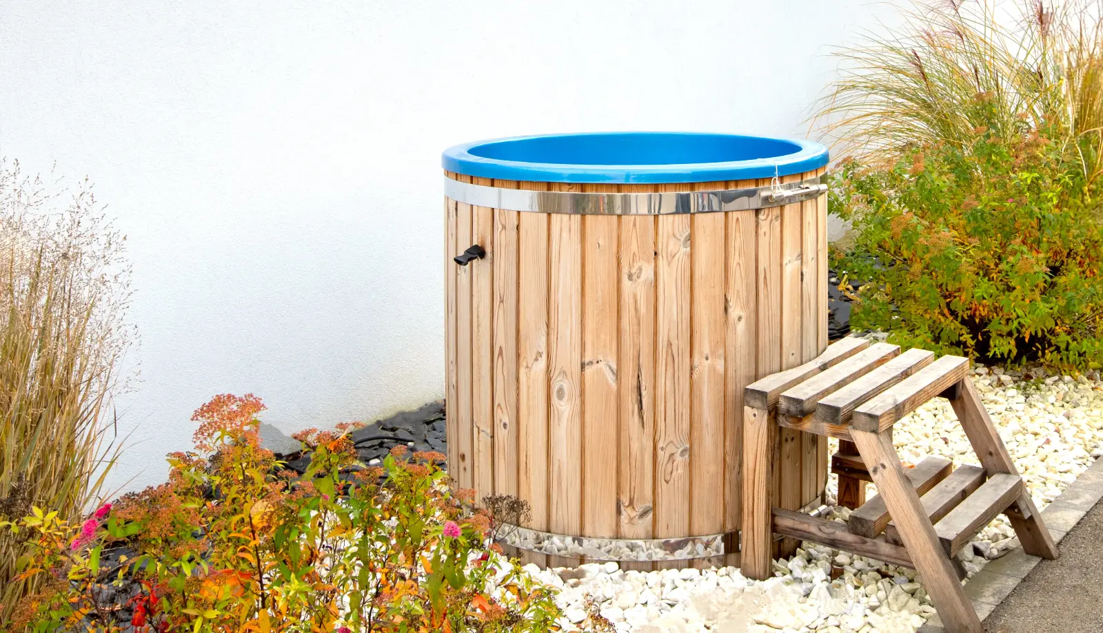 Bain nordique en bois du gîte Porte D, installé en extérieur dans un jardin végétalisé.
