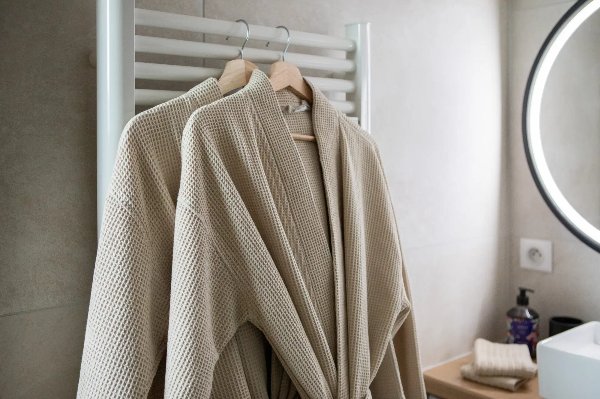 Peignoirs doux suspendus dans la salle de bain du gîte Porte D.